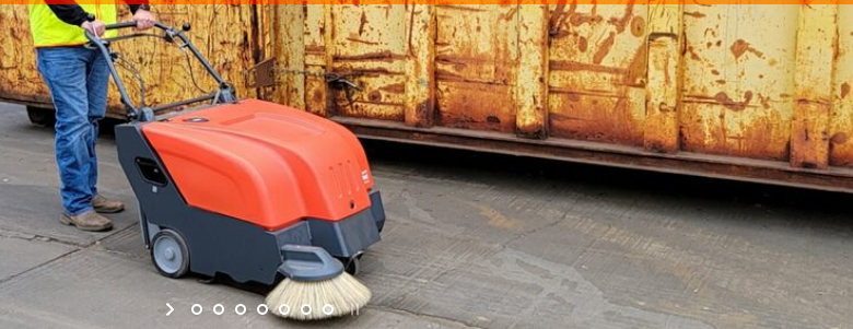 Operator using a PowerBoss walk-behind sweeper
